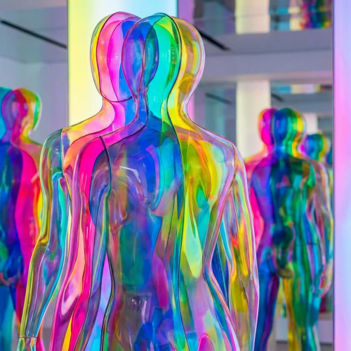 Multiple translucent mannequins with overlapping rainbow colors in a mirrored room