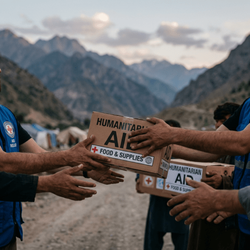 Volunteers handing over boxes labeled humanitarian aid and food supplies outdoors