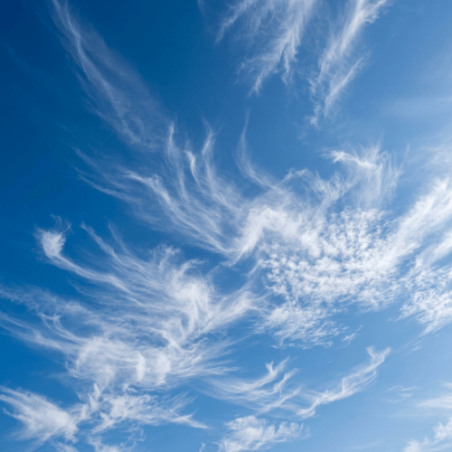 Feathery cirrus clouds scattered across a vivid blue sky